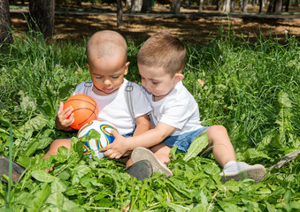 Little boys: African American and caucasian  with soccer ball