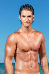 Portrait of a handsome young muscular man in swimwear