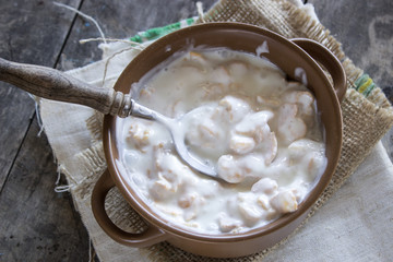 Bowl of cornflakes on wooden table.