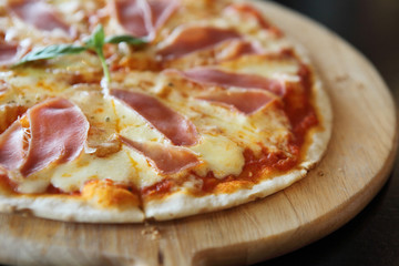Pizza with dry cured ham and basil