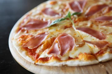 Foto op Plexiglas Pizzeria Pizza met gedroogde ham en basilicum