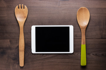 two wooden spoons and tablet computer