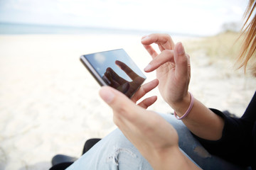 Frau mit Smartphone am Strand