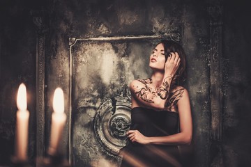 Tattooed beautiful woman in old spooky interior