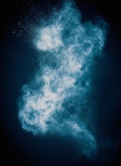 Blue powder exploding isolated on black