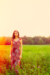 Stylish young woman standing in a morning meadow
