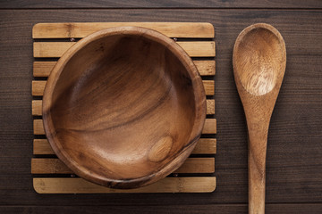 wooden salad plate and spoon on brown table