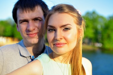 Portrait of a young in love couple on the embankment