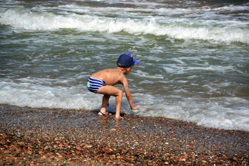niño jugando en la orilla de mar