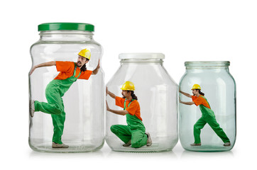 Man in coveralls imprisoned in glass jar