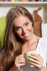 Close-up portrait of a beautiful young woman drinking a cup of t
