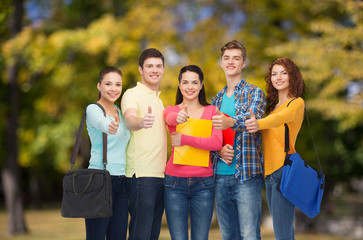 group of smiling teenagers showing thumbs up
