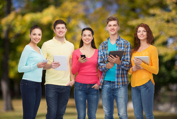group of teenagers with smartphones and tablet pc