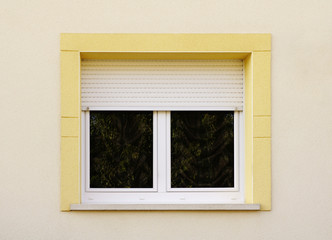 Modernes Fenster mit Rollladen und gelber Fenstereinfassung