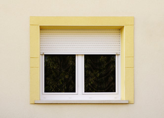 Modernes Fenster mit Rollladen und gelber Fenstereinfassung