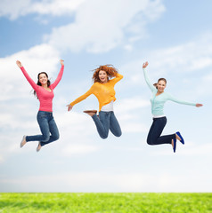 Fototapeta na wymiar group of smiling young women jumping in air