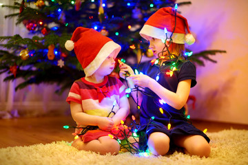 Two little sisters decorating a Christmas tree