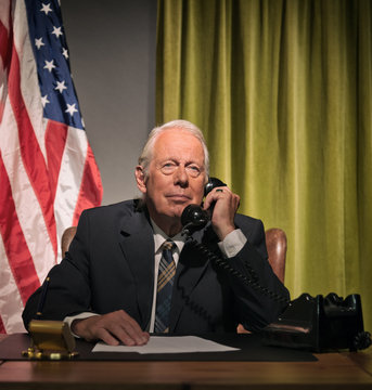 Big Boss President Calling Behind Desk With American Flag In The