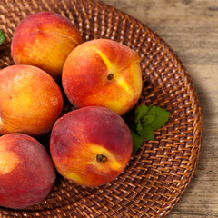 Fresh peaches on wood background. Selective focus.