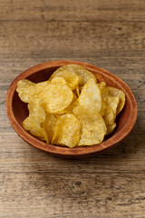 Crispy potato chips on wooden background
