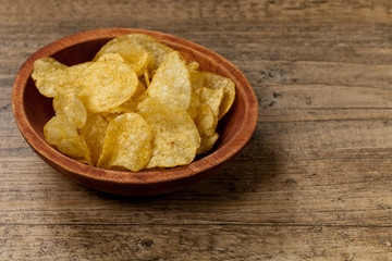Crispy potato chips on wooden background
