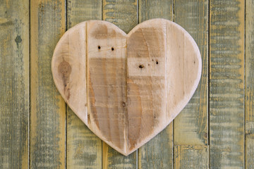 Love Valentines wooden heart on light green painted background