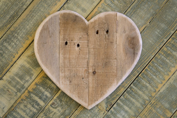 Love Valentines wooden heart on light green painted background