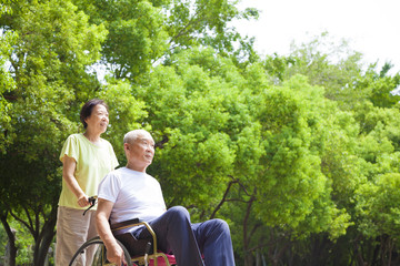 Asian senior man sitting on a wheelchair with his wife