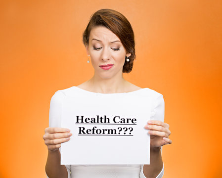 Skeptical woman holding sign health care reform?