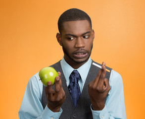Man craving cigarette versus green apple on orange background 