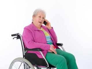 female senior in wheelchairis calling