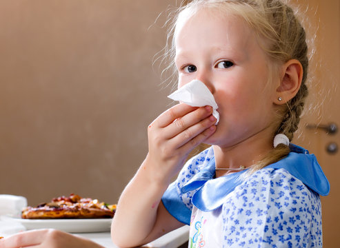 Pretty Little Girl Wiping Her Mouth With A Napkin