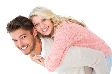 Handsome man giving piggy back to his girlfriend