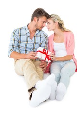 Attractive young couple sitting holding a gift