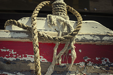 Fototapeta premium Detail of rusty wooden plate and a rope on a boat