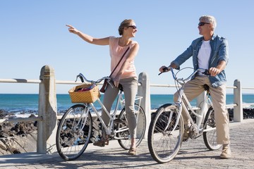 Happy casual couple going for a bike ride on the pier