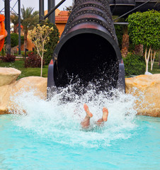 Man fell from waterslide to water with splashes in waterpark