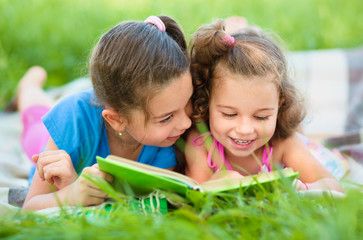 Two little girls are reading book