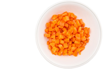 Chopped carrot in a bowl over white background