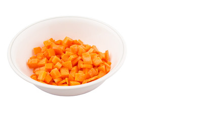 Chopped carrot in a bowl over white background
