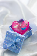 Blue present box with pink heart of glass in it
