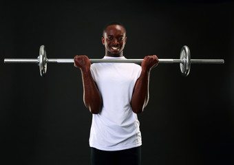 Fototapeta na wymiar happy african man working out with barbell