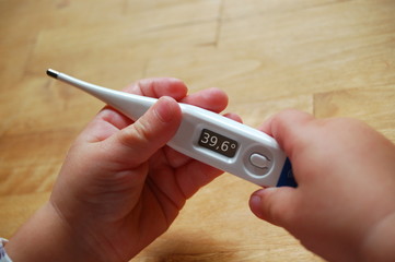 Kinderhände mit Fieberthermometer