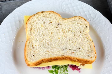 Foto auf Acrylglas gezonde boterham met kaas op een wit bord © trinetuzun