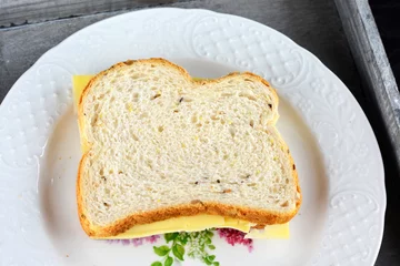 Foto auf Acrylglas gezonde boterham met kaas op een wit bord © trinetuzun