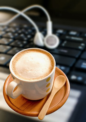 Coffee cup with  headphones on laptop
