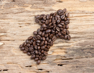 Arrow from the coffee beans on wood background