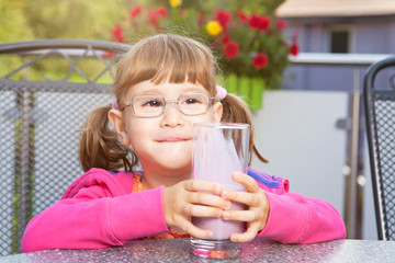 KLeines Mädchen genießt seinen Milchshake