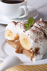 Piece of banana cake with cream and coffee close-up