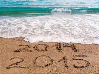 Happy New Year 2015 replace 2014 concept on the sea beach 